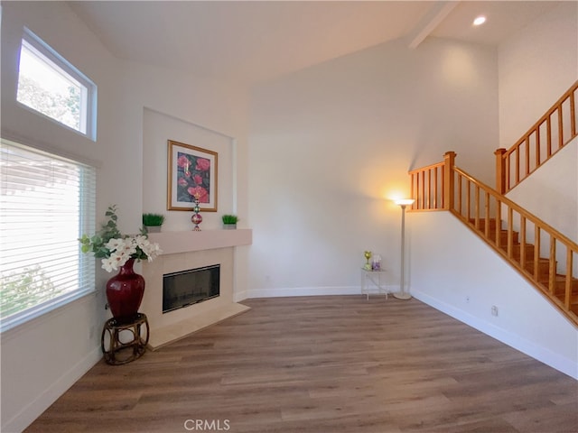 1911 E Calico Dr, West Covina, CA 91791 - unfurnished living room featuring wood finished floors, beamed ceiling, a tile fireplace, stairs, and baseboards