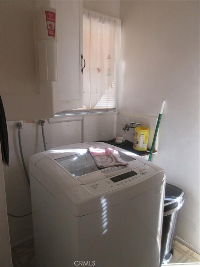 laundry room with water heater and washer / dryer