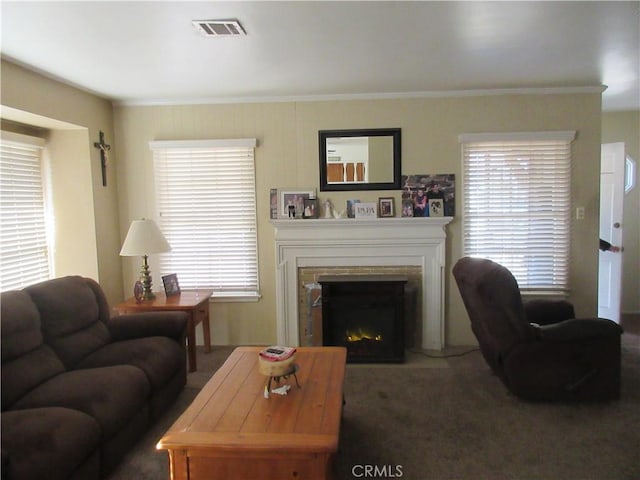 living room with dark colored carpet, crown molding, and a healthy amount of sunlight