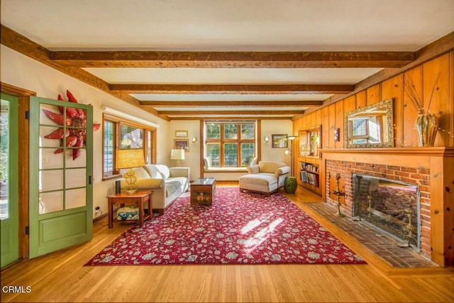 living room featuring a healthy amount of sunlight, beamed ceiling, and a fireplace