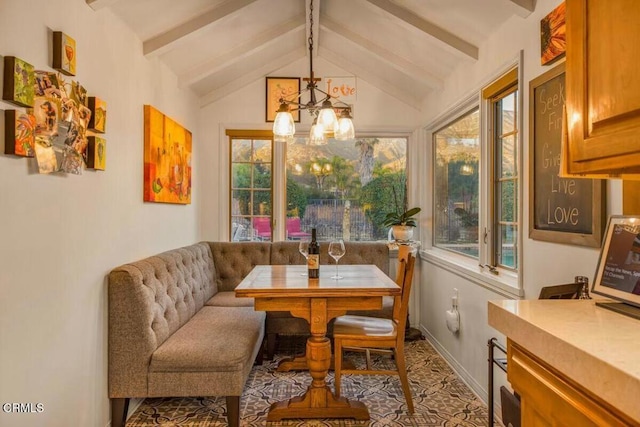 dining area featuring lofted ceiling with beams, breakfast area, and a notable chandelier