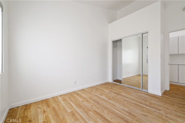 unfurnished bedroom featuring a closet and light wood-type flooring