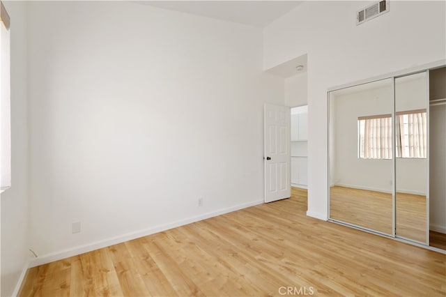 unfurnished bedroom with a closet and hardwood / wood-style flooring