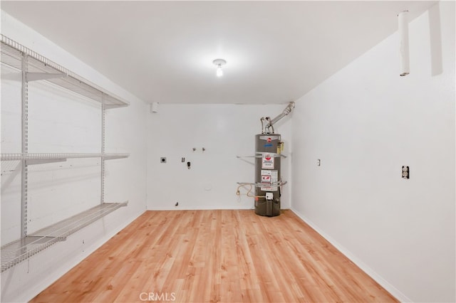 basement with water heater and hardwood / wood-style floors