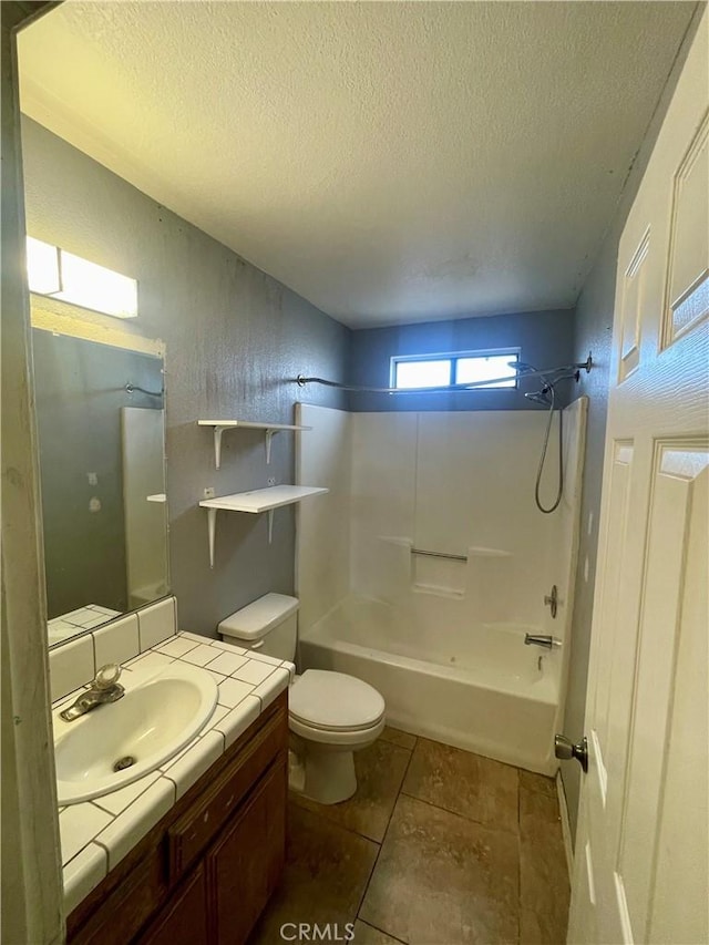 full bathroom featuring shower / bath combination, vanity, toilet, tile patterned floors, and a textured ceiling