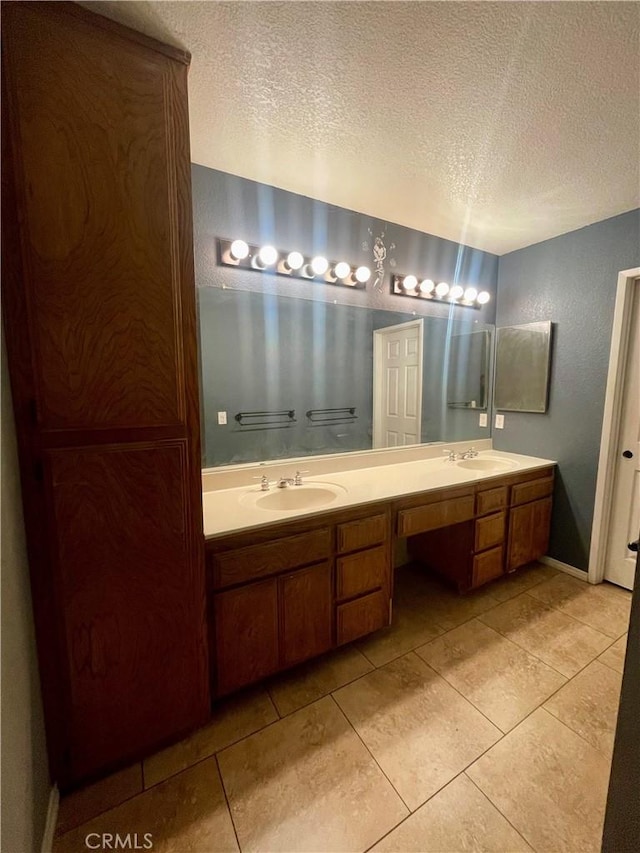 bathroom featuring vanity, tile patterned floors, and a textured ceiling