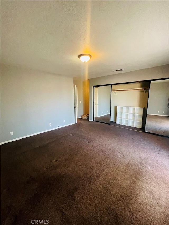 unfurnished bedroom featuring a closet, a textured ceiling, and carpet flooring