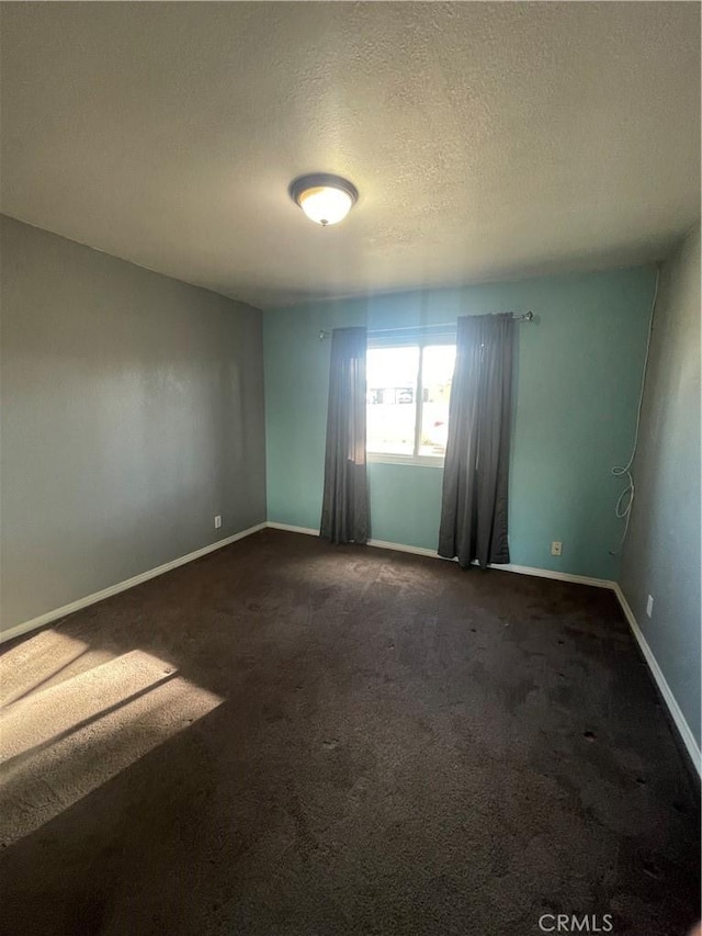 carpeted spare room featuring a textured ceiling