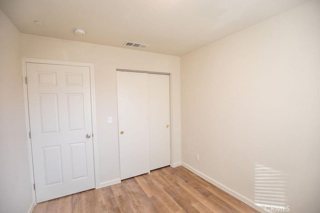 unfurnished bedroom featuring light hardwood / wood-style floors and a closet