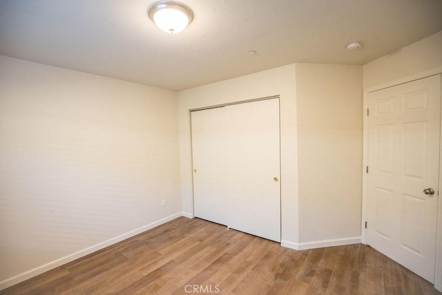 unfurnished bedroom with a closet and light hardwood / wood-style floors