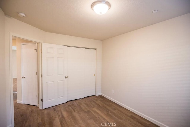 unfurnished bedroom featuring hardwood / wood-style flooring and a closet