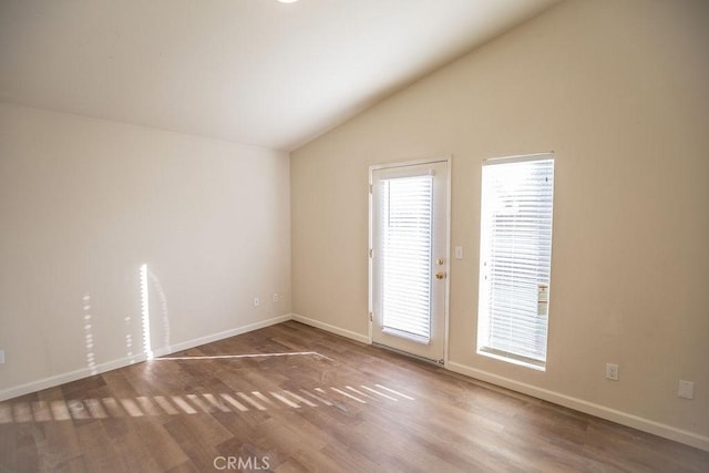 empty room with lofted ceiling and hardwood / wood-style floors