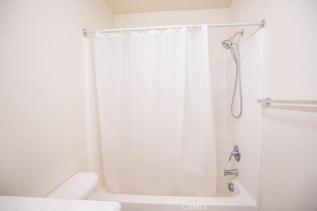 bathroom with toilet and shower / tub combo with curtain