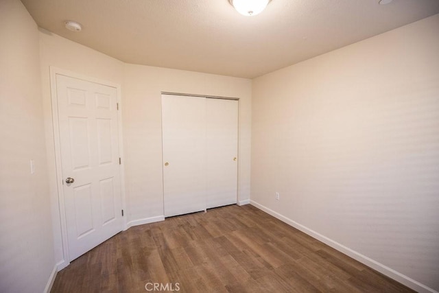 unfurnished bedroom featuring wood-type flooring and a closet