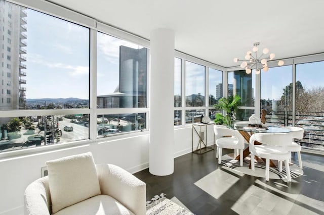 sunroom featuring plenty of natural light and a notable chandelier