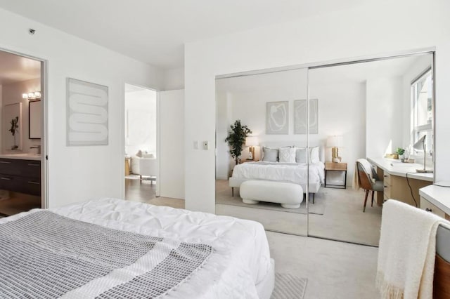 bedroom with light carpet, ensuite bath, and a closet