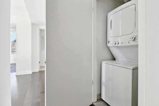 clothes washing area with stacked washing maching and dryer