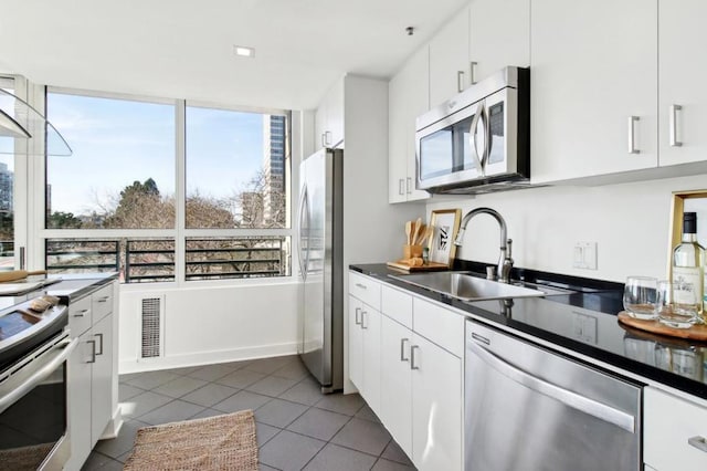 kitchen with stainless steel appliances, white cabinetry, and sink