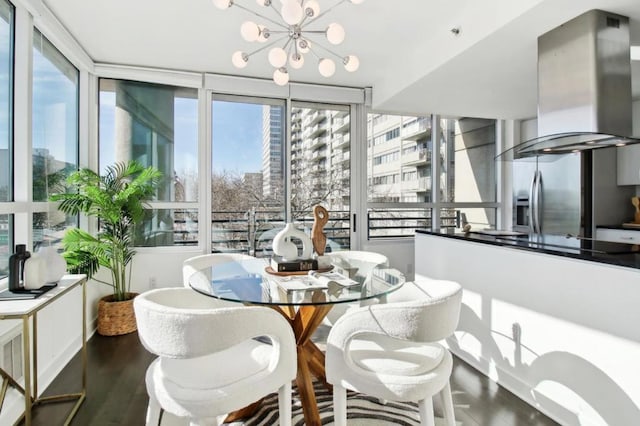 dining space featuring dark hardwood / wood-style floors, an inviting chandelier, and a healthy amount of sunlight