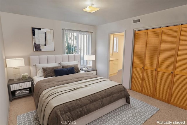 bedroom with connected bathroom, carpet floors, and a closet