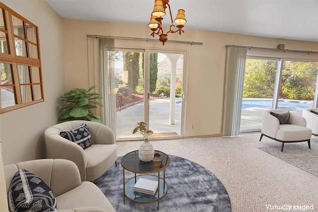 living area featuring a notable chandelier and carpet flooring