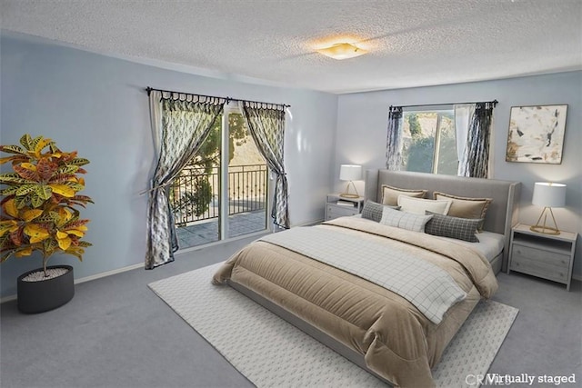 carpeted bedroom featuring access to exterior and a textured ceiling