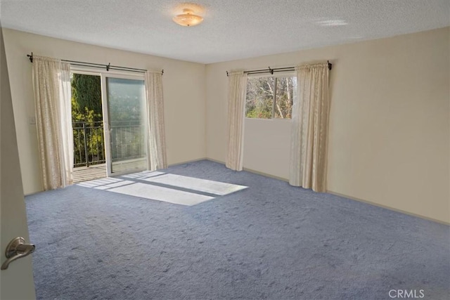 carpeted spare room with a textured ceiling