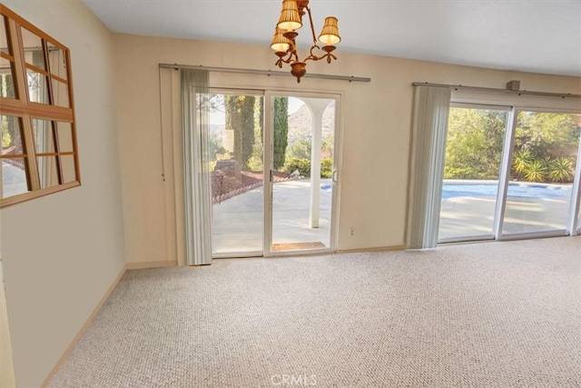 interior space featuring a healthy amount of sunlight, a chandelier, and carpet