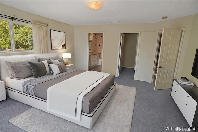 bedroom featuring carpet flooring and connected bathroom