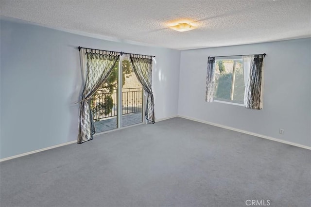 carpeted spare room with a textured ceiling