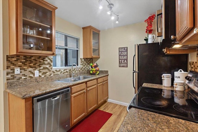 kitchen with sink, light stone counters, tasteful backsplash, stainless steel appliances, and light hardwood / wood-style floors