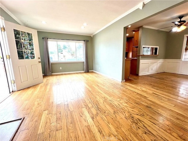 interior space with crown molding, a ceiling fan, and light wood-style floors