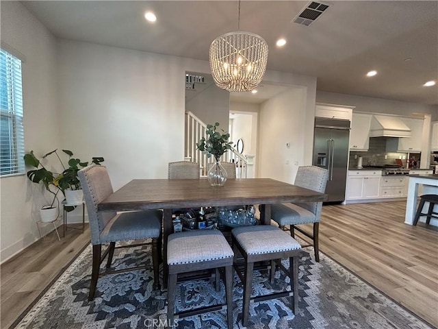 dining area with an inviting chandelier and wood-type flooring