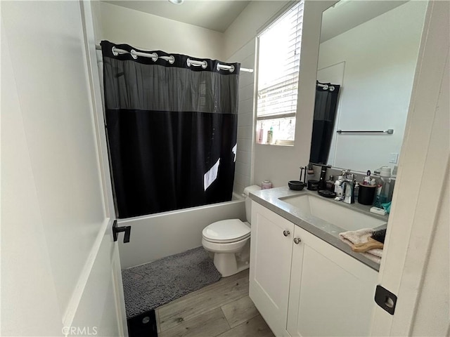 full bathroom with toilet, vanity, hardwood / wood-style flooring, and shower / bath combo with shower curtain