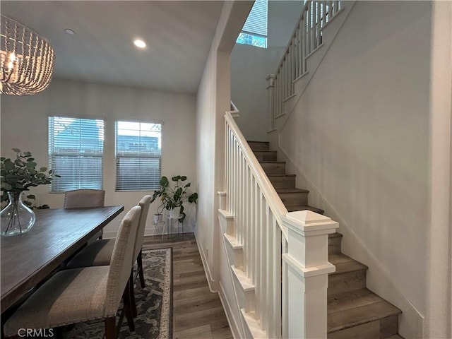 stairway with a chandelier and wood-type flooring