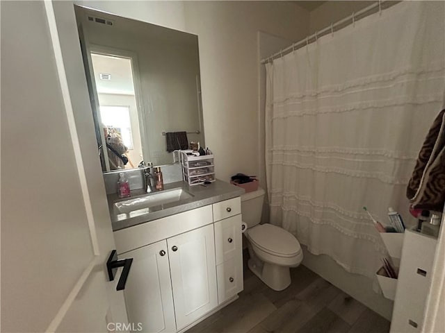 full bathroom featuring toilet, shower / tub combo, vanity, and hardwood / wood-style floors