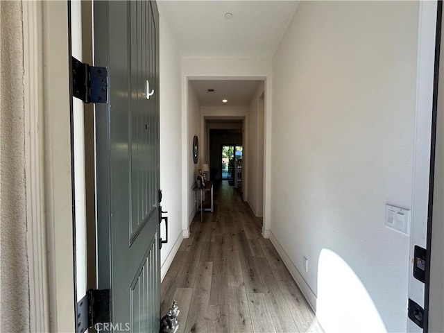 corridor with light hardwood / wood-style floors