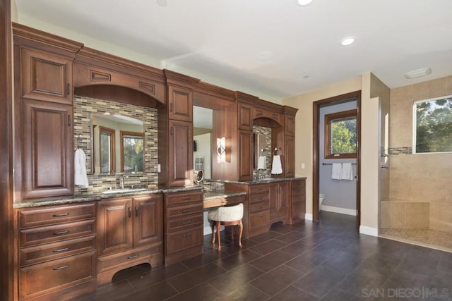 bathroom featuring backsplash, toilet, and vanity