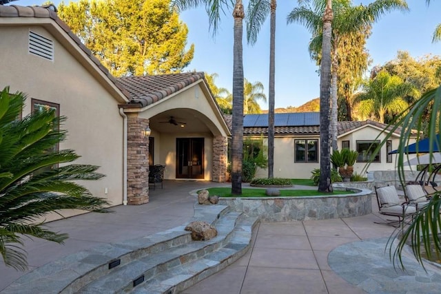 back of house featuring a patio area, solar panels, and ceiling fan