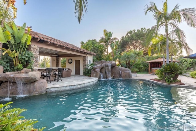 view of swimming pool with a patio area, ceiling fan, a gazebo, and pool water feature