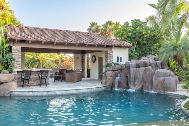 view of swimming pool featuring pool water feature, a bar, a gazebo, and an outdoor hangout area