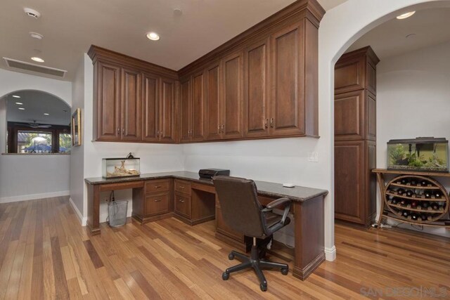 office with light hardwood / wood-style floors and built in desk