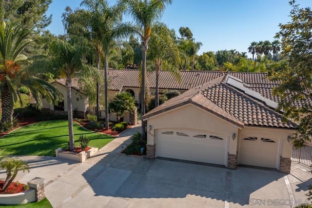 mediterranean / spanish-style home with a front yard and a garage