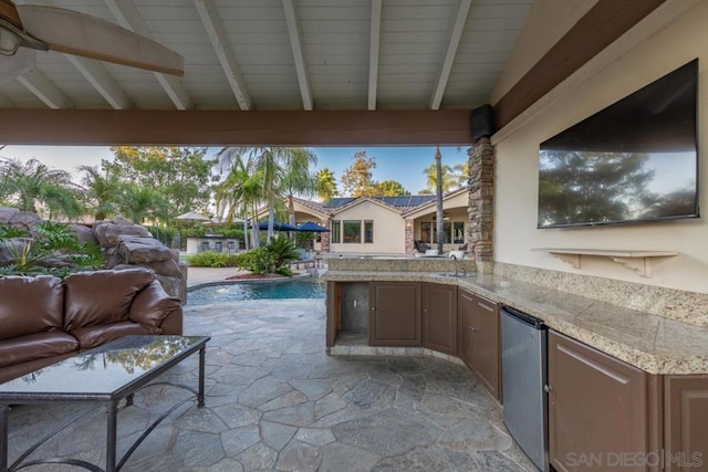 view of patio / terrace with area for grilling, an outdoor wet bar, and ceiling fan