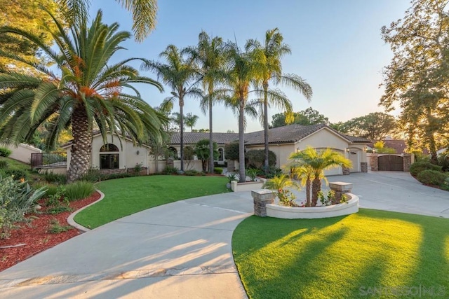 mediterranean / spanish-style home featuring a garage and a front lawn