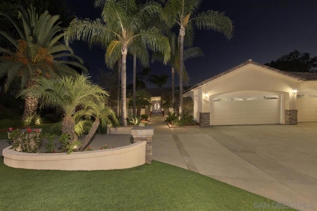 view of front of property with a garage and a lawn