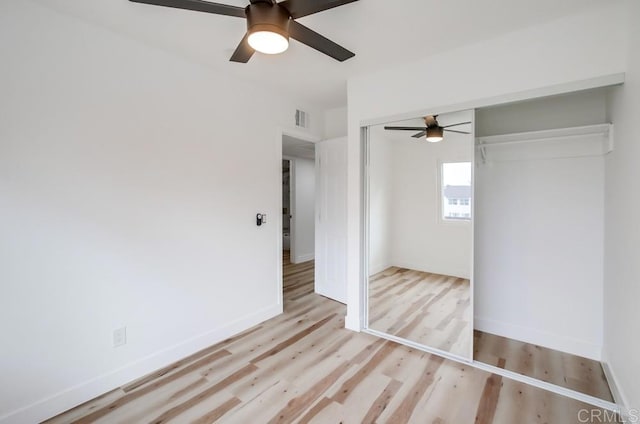 unfurnished bedroom featuring ceiling fan, a closet, and light hardwood / wood-style flooring