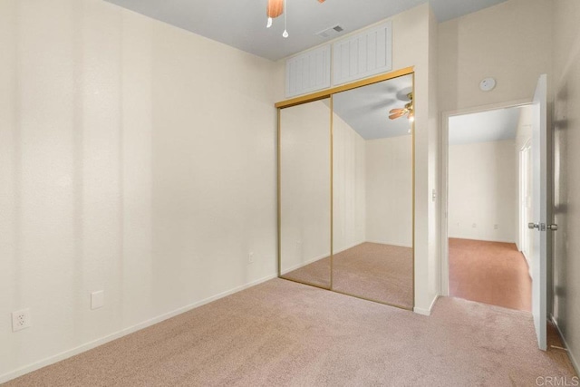 unfurnished bedroom with ceiling fan, a closet, and light carpet