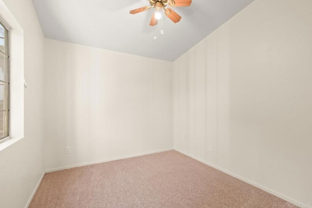 carpeted spare room with ceiling fan