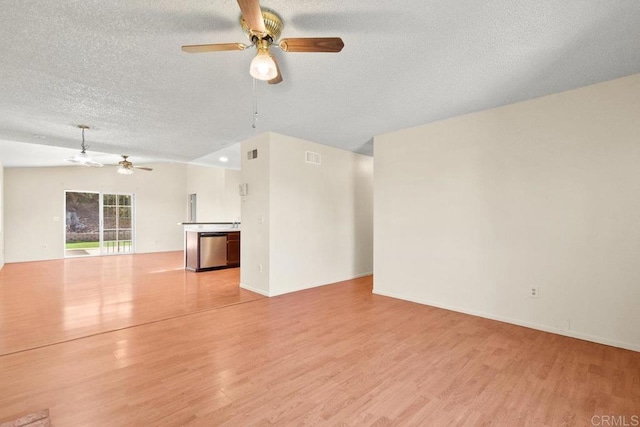 unfurnished living room with light hardwood / wood-style floors, a textured ceiling, ceiling fan, and vaulted ceiling